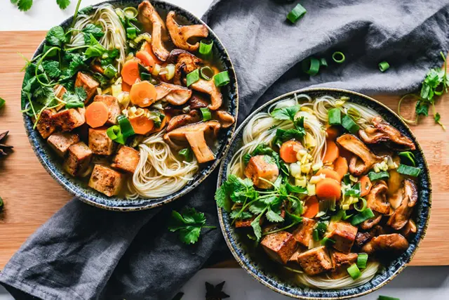Schüsseln mit gebratenem Tofu, Nudeln und Gemüse